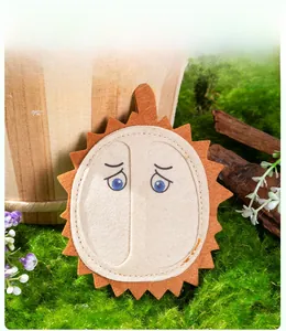 Macro detail of felt durian cat toy with cute expression on green moss background