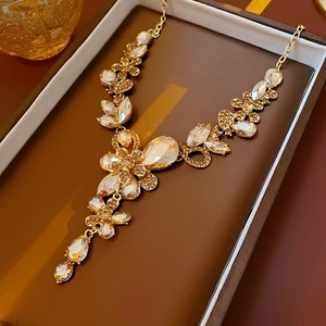Detailansicht der goldenen Blumenkette mit Wassertropfen-Kristallen in einer Box