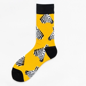 Dettaglio dei calzini gialli con motivo a zebra bianco e nero e dettagli neri sui talloni