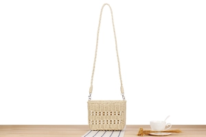 Gros plan sur la texture de ce sac en paille tressée avec perles blanches élégantes