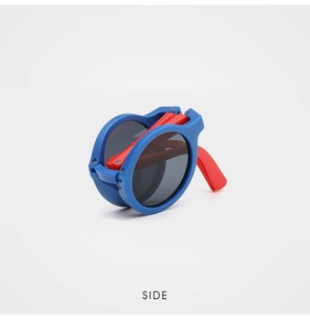 Side view of foldable kids sunglasses with bright blue round frames and red temples