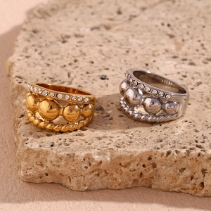Detailed shot of two multi-layered stainless steel rings with gold plating and rhinestones