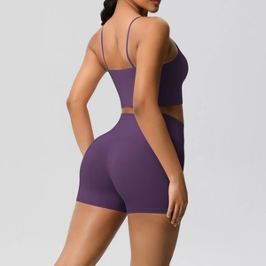 Detail of purple yoga set showing thin straps and high-waisted shorts on a model