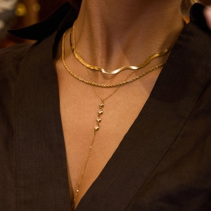 Close-up of layered 18K gold stainless steel snake chain and Y-necklace with white zircon