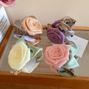 Lot de quatre pinces à cheveux florales en crème, pêche, violet et orange sur plateau