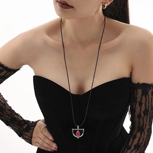 Collana lunga gotica con pendente a goccia rossa su una corda nera intrecciata a mano