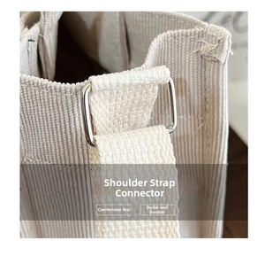 Macro shot of silver buckle and beige corduroy fabric detail on a crossbody bag