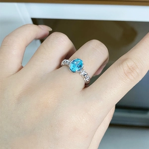 Close-up of S925 silver ring with oval neon blue gemstone and tiny pavé diamonds