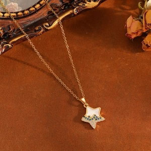 Detail of gold star pendant necklace with white enamel and blue diamonds on vintage background