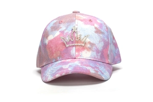 Detailed view of the sparkling rhinestone crown on the pink and purple tie-dye baseball cap