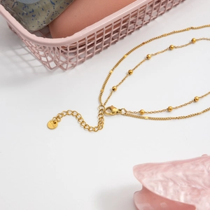 Close-up of double-layer gold stainless steel chain with lobster clasp and S.Steel tag