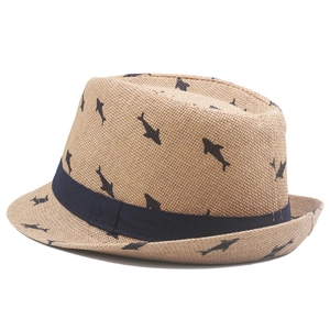 Detail of woven straw fedora hat for kids with dark blue ribbon and shark prints