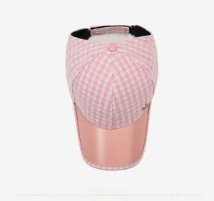 Vue de dessus d'une visière pied-de-poule rose en tweed avec bord en cuir poli
