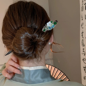 Detail of Chinese style hair pin with green beads, shell flowers and silver tassels
