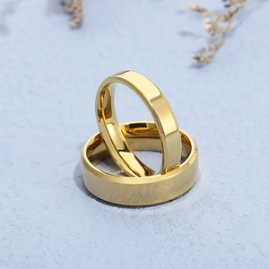 Close-up of dual gold stainless steel rings with beveled edges on light blue background