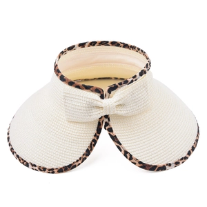 Detailed macro view of beige straw sun visor with leopard print trim and bow detail