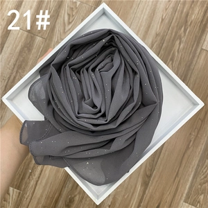 Détail du foulard en mousseline gris foncé avec des strass argentés brillants