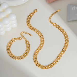 Goldene Gliederkette und Armband auf weißem Hintergrund mit minimalistischen Requisiten