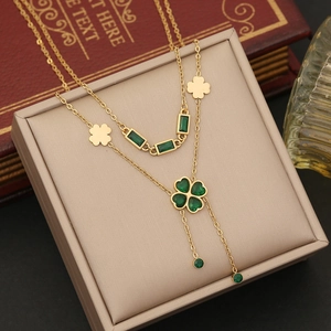 Macro shot of gold emerald clover necklace with heart-shaped stones on jewelry display
