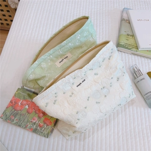 Close-up of green and white jacquard lace cosmetic bag with embossed fabric texture