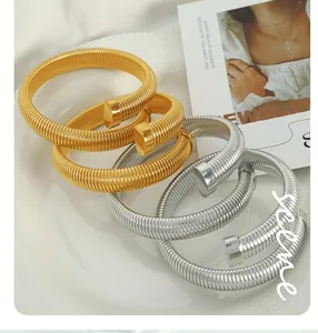 Close-up of spiral titanium steel bracelets in gold and silver finish with elastic design