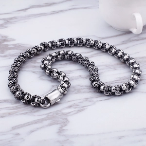 Detailed close-up of a punk skull bracelet with antique silver finish on white marble