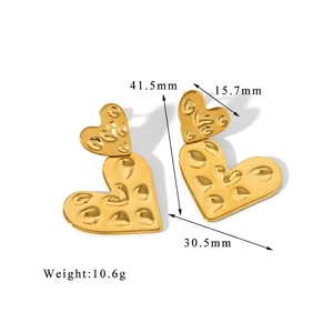 Detailed view of gold heart drop earrings featuring hammered texture and dual heart design