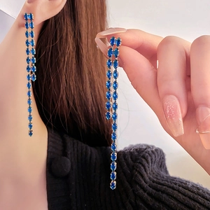 Detail shot of elegant blue marquise crystal fringe drop earrings on a model
