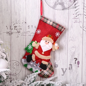Detail of red fabric Christmas stocking with 3D Santa Claus and snowflake pattern