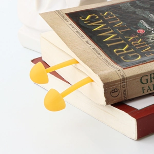 Creative yellow mushroom silicone bookmark placed inside a vintage Grimm's Fairy Tales book