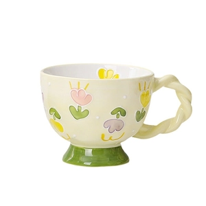 Hand-painted floral ceramic mug with a cream yellow finish and a stylish twisted handle