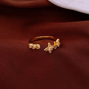 Close-up of gold plated star ring with zircon accents on a red velvet background