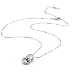 Macro detail of silver interlocking double ring pendant with white cubic zirconia inlay
