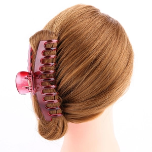 Close-up of a large burgundy hair claw clip holding long hair on a model head back view