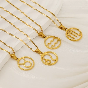 Detailed close-up of four gold stainless steel zodiac necklaces on white texture