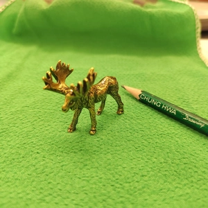 Detailed close-up of a vintage brass elk figurine showing fine metal texture and antlers
