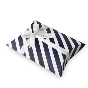 Blue and white striped pillow gift box with white ribbon bow and Thank You tag