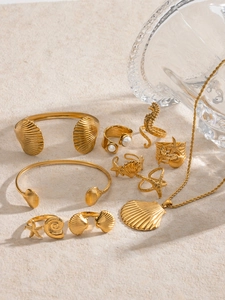 Détail d'un ensemble de bijoux marins en or 18k avec coquillages et perles sur pierre