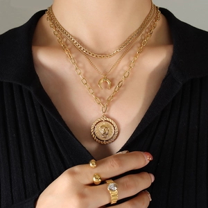 Three-layer gold necklace with crescent moon and lion head coin pendants and matching rings
