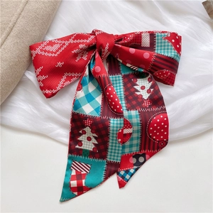 Detail of Christmas themed satin skinny scarf with festive snowflake and tree patterns
