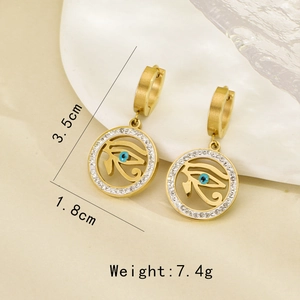 Detail view of gold drop earrings featuring blue evil eye charms with pavé crystals