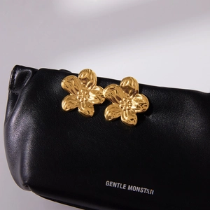 Vintage 18K vergoldete Edelstahl Blumenohrringe auf schwarzem Leder präsentiert