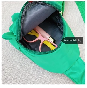 Internal view of green nylon kids crossbody bag showing capacity with glasses inside