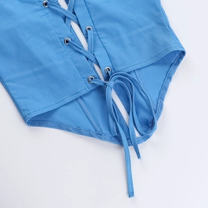 Détail du haut bleu à lacets montrant des oeillets métalliques et la texture du tissu
