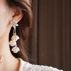 Macro shot of silver needle flower earring with zircon tassels and hanging pearls