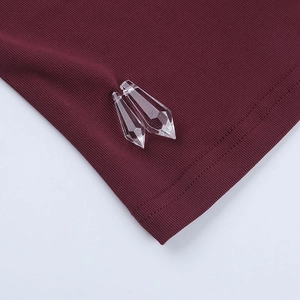 Detail of burgundy ribbed knit fabric with transparent crystal drop pendants decoration