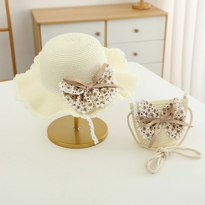 Dettaglio cappello di paglia per bambina e borsa coordinata con pizzo e fiocchi