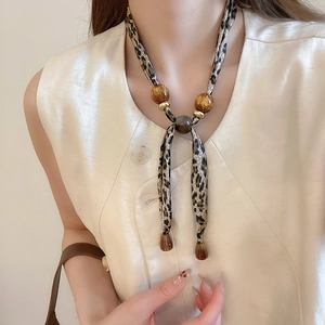 Détail du collier foulard léopard avec perles en résine ambrée et anneaux dorés