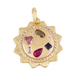 Close-up of golden sunburst pendant with multicolored crystals and pink heart gem