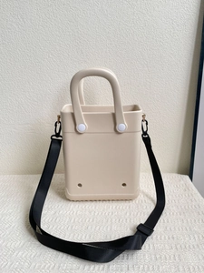 Detail view of beige EVA tote bag with adjustable black nylon strap and side hooks